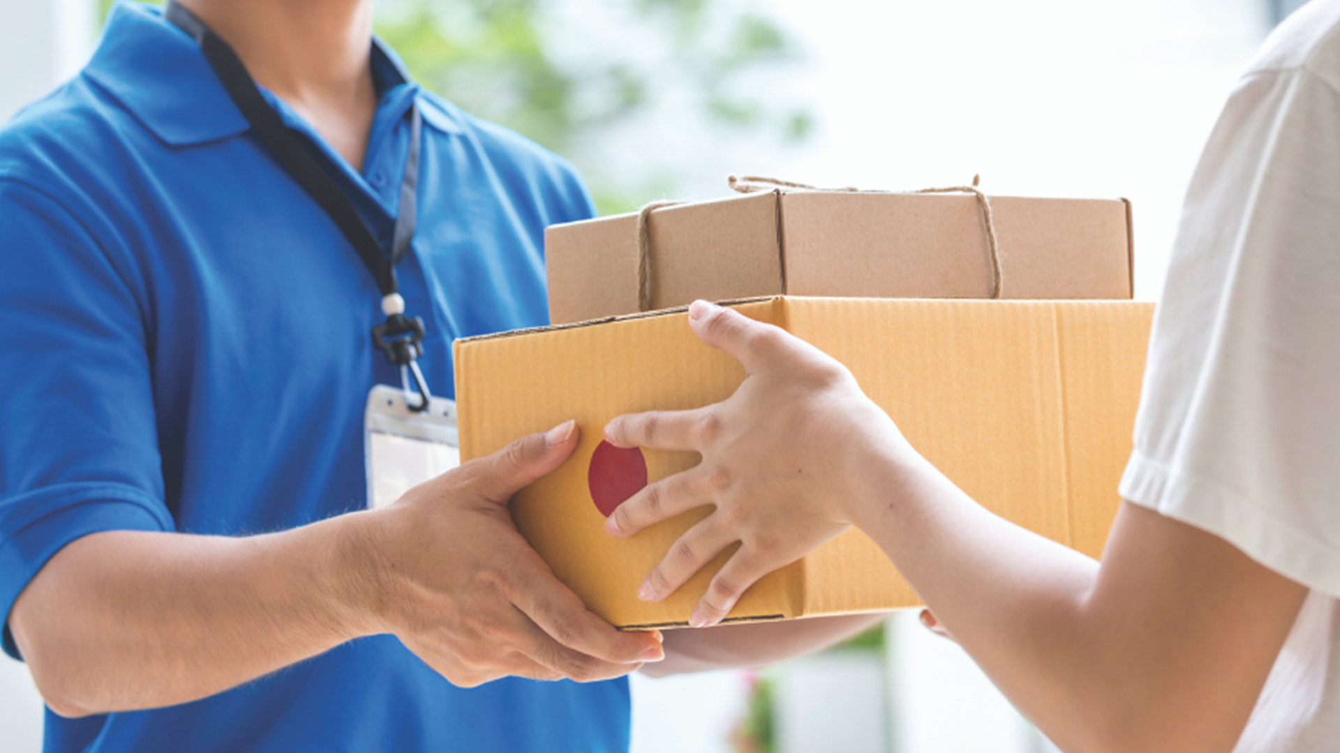 Postal worker passing a package to recipient